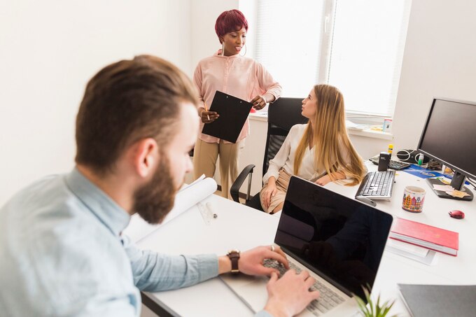 man working near speaking colleagues